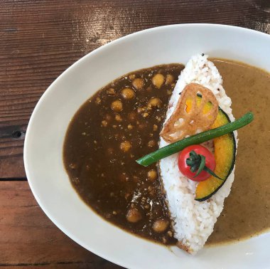 Yakın plan bir porsiyon pirinçli köri ve masada köri.