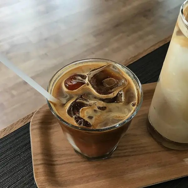 Ahşap masada buzlu kahve ve süt.