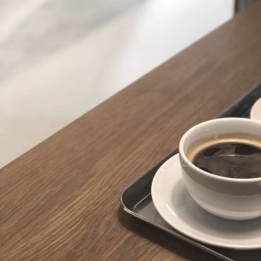 Masada beyaz köpüklü bir fincan sade kahve.