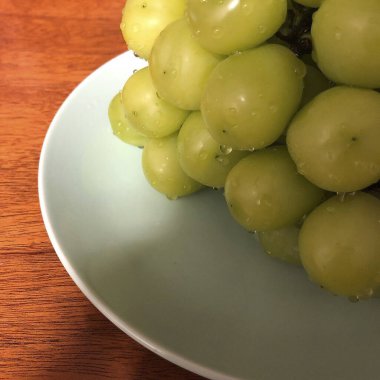 Yeşil arka planı olan bir tabakta üzümler