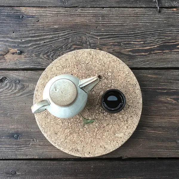 Sade kahve ve beyaz tabaklı bir çaydanlık.