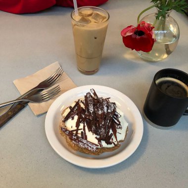 Kahve, çikolata ve krema ahşap masada.