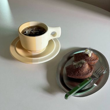 Beyaz tabakta bir fincan çay ve kek