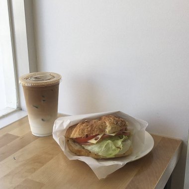 Lezzetli bir sandviçle bir fincan kahvenin yakın çekimi.