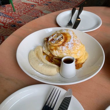 Tabağında bal ve krema olan krepler.