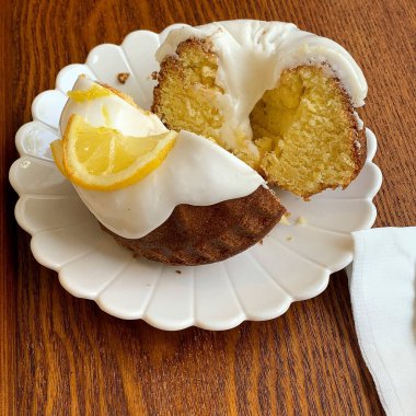 Kremalı limonlu kek ve çatal ve bıçaklı beyaz tabakta limon. Manzarayı kapat. yüksek kaliteli fotoğraf