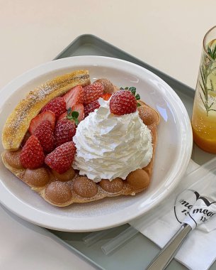 Çilekli ve kremalı lezzetli çikolatalı waffle.