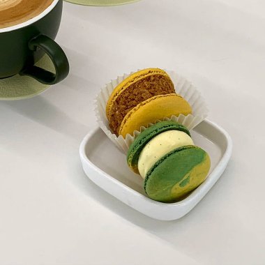 Kurabiyeli yeşil çay ve beyaz arka planda bir fincan kahve.