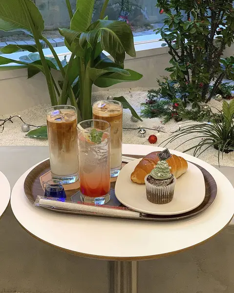 Limonlu bir fincan kahve ve ahşap bir masada bir mum.