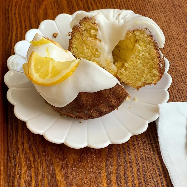 Kremalı limonlu kek ve çatal ve bıçaklı beyaz tabakta limon. Manzarayı kapat. yüksek kaliteli fotoğraf