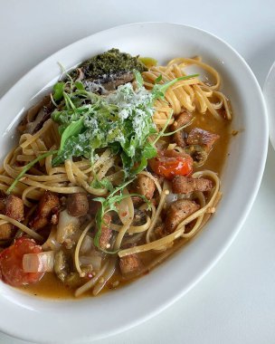 Tabakta deniz mahsulleri ve bitkiler olan lezzetli bir makarna.