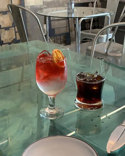 Masanın üzerinde bir bardak şarapla bir kokteylin yakın plan çekimi.