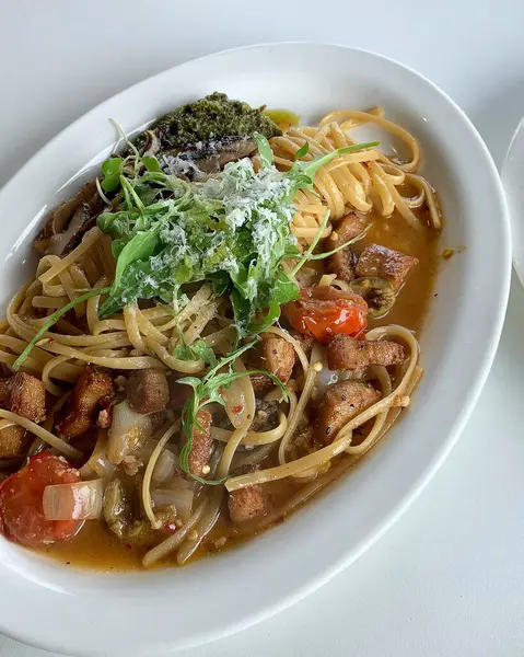 Tabakta deniz mahsulleri ve bitkiler olan lezzetli bir makarna.