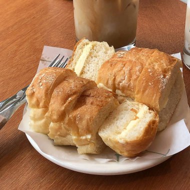 Tahta bir masada tereyağı ve sütle taze ekmek.