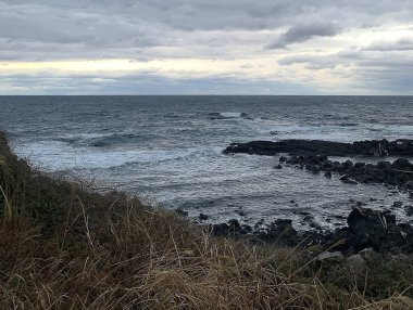 Bulutlu bir gökyüzü ile güzel bir deniz manzarasının yakın çekimi.