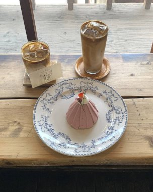 Bir fincan kahve ve ahşap masada bir pasta.