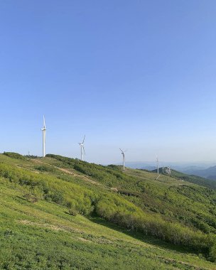 Dağlardaki tepede rüzgar türbinleri