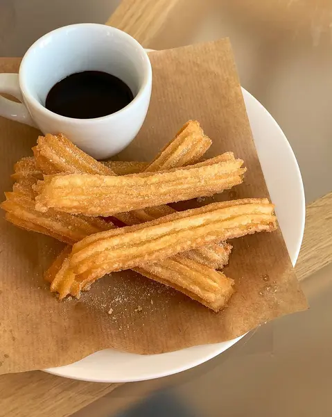 Bir fincan kahve ve lezzetli tarçın çubukları.