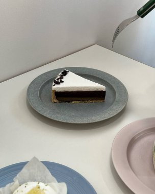 Beyaz bir masanın üzerinde duran bir kekin dikey fotoğrafı.