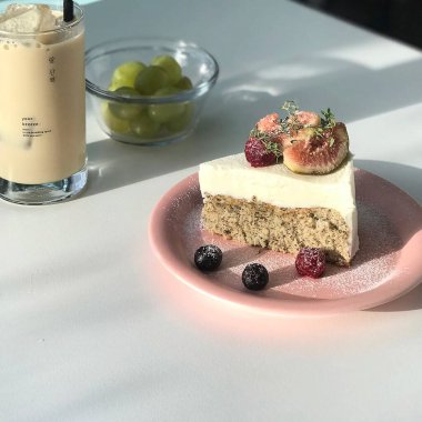 Bir parça kremalı kek ve masanın üzerindeki tabakta bir fincan kahve.