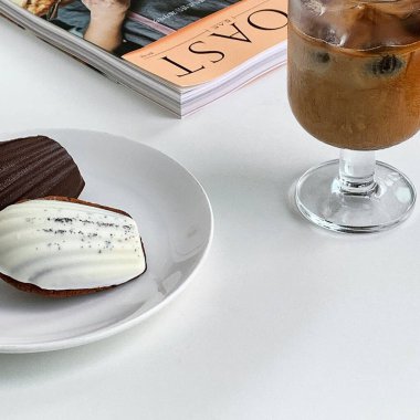 Tahta bir masada bir fincan kahve ve kurabiye.