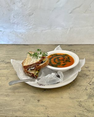 Bir dilim lezzetli çorba, beyaz tabak ve bir dilim ekmek ile dikey yakın çekim.