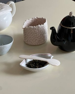 Bir fincan, çay, çaydanlık ve masanın üzerine bir fincan çay.