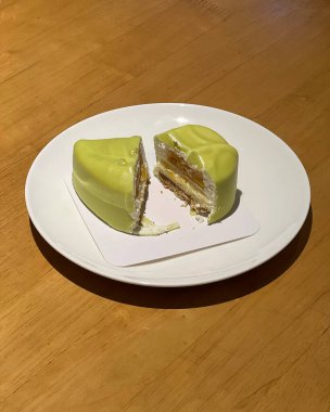 Kremalı kek ve tabakta yeşil çay.