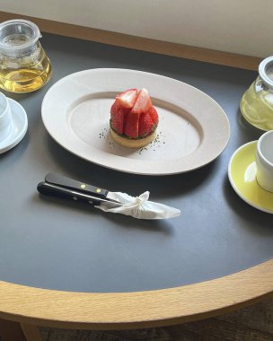 Bir fincan çay ve beyaz bir masada kek.