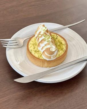 Masanın üzerinde yakın plan beyaz pasta resmi var.