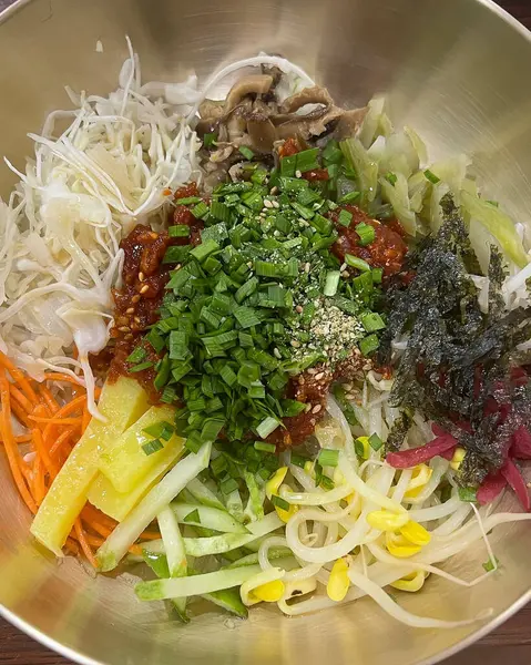 Geleneksel Kore eriştelerini sebze ve kimchi ile kapatın.