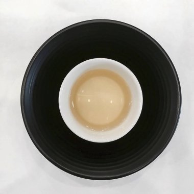 Bir fincan siyah çay ve beyaz tabak.