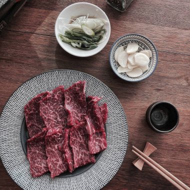 Baharatlı biftek ve siyah tabakta taze biftek.