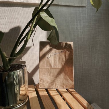 Masanın üzerinde beyaz ve sarı bir kesekağıdının dikey görüntüsü.