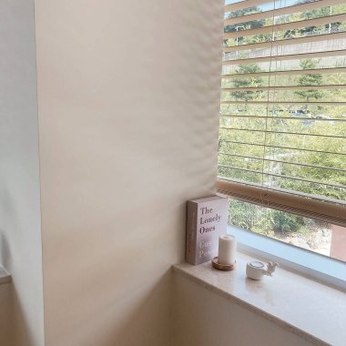 Pencere kenarında beyaz bir kitapla bir fincan kahve.