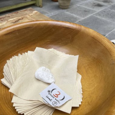 Tahta bir masanın üzerinde peçeteli boş beyaz tabak..