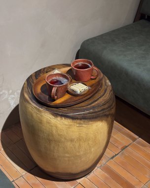 Bir fincan kahveyle ahşap bir masanın yakın çekimi.