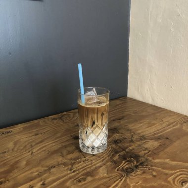 Ahşap masada cam kavanozda buzlu kahve.