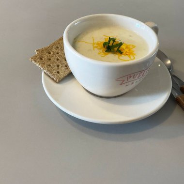 Bir kase çorba, ekmek, kaşık ve bir fincan sıcak çay.