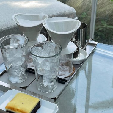 Masada bir bardak buz ve bir fincan kahve.