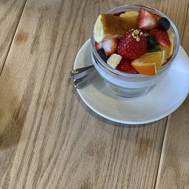 Bir fincan taze çilek ve kaşıklı kaşık.