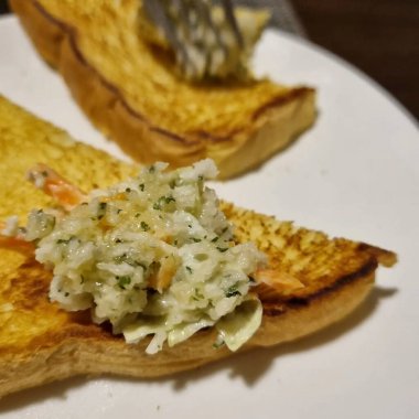 Sarımsaklı kızarmış somon, ekmek ve peynir.