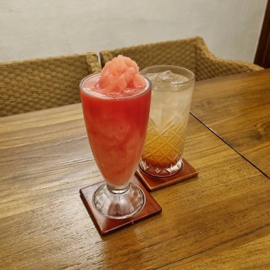 Bir bardak buzlu çay ve masada pipet.