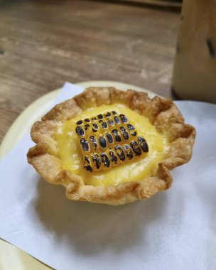 Tahta arka planda kremalı ve çikolatalı lezzetli bir tart.