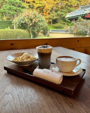 Tahta bir masada bir fincan kahve ve bir fincan çay.