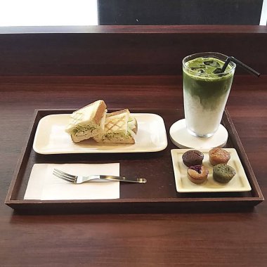 Tahta bir masada bir bardak çay ve bir fincan kahve.