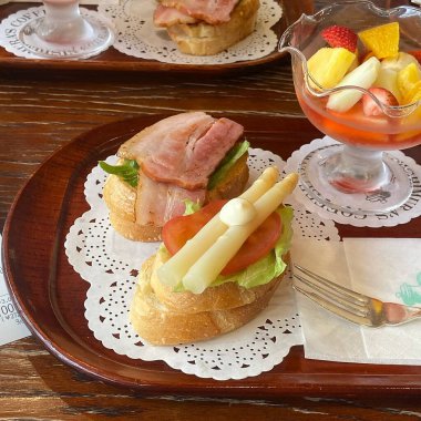 Bir bardak şampanya ve bir fincan kahveyle sandviçin yakın plan çekimi.