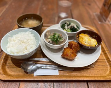 Japon pirinci, kızarmış tavuk ve sebzeli pilav ahşap masada.