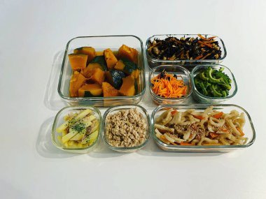 Beyaz arka plandaki konteynırlarda çeşitli yiyecekler