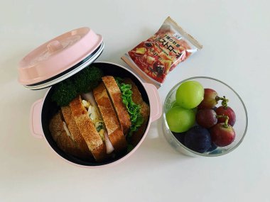 Beyaz arka planda sandviçli beslenme çantası.